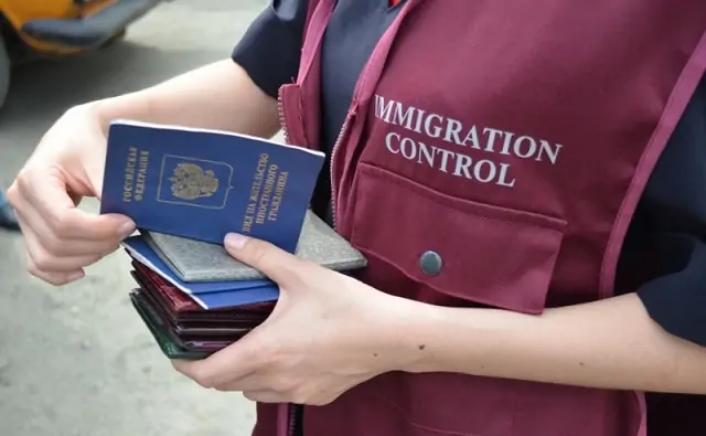 Сотрудник управления по вопросам миграции с паспортами. Фото 74.мвд.рф