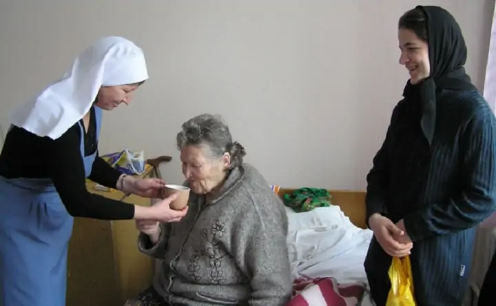 Представительницы христианской организации помогают женщине. Фото miloserdie.ru