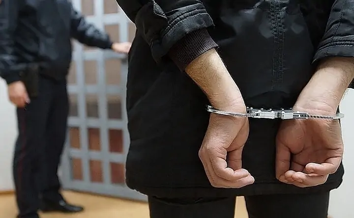Страж порядка и задержанный человек в наручниках. Фото stolica-s.su