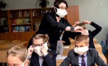 Учитель надевает маски на детей. Фото bnp.by.