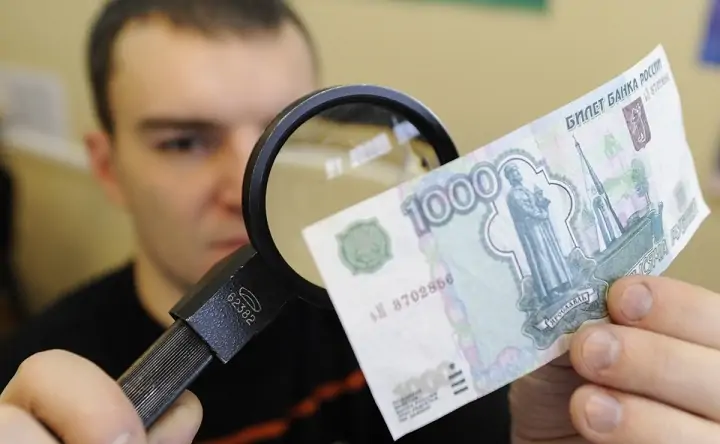 Проверка купюры на подлинность. Фото gradnews.ru