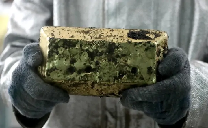 Сотрудник Таласского золоторудного комбината держит в руках слиток золота. Фото РИА.