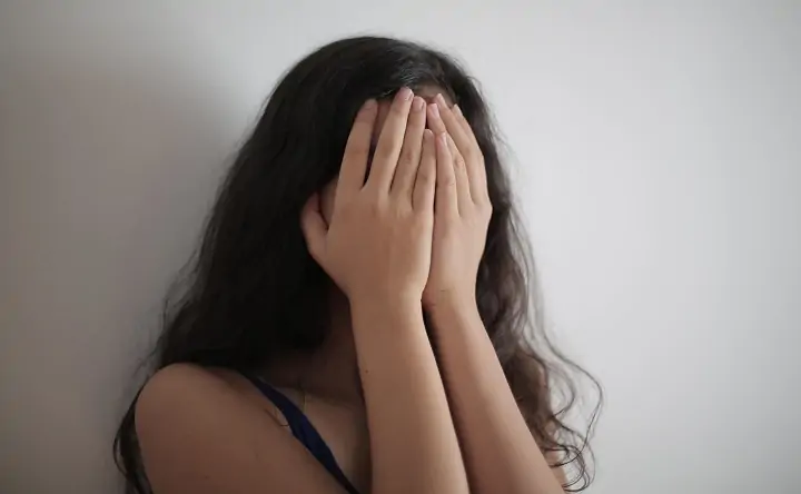 Девушка закрывает лицо руками. Фото pexels.com