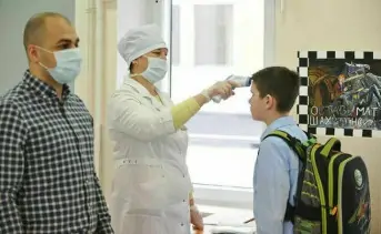 Медсестра меряет температуру ребёнку на входе в школу. Фото © Александр Авилов, АГН «Москва»