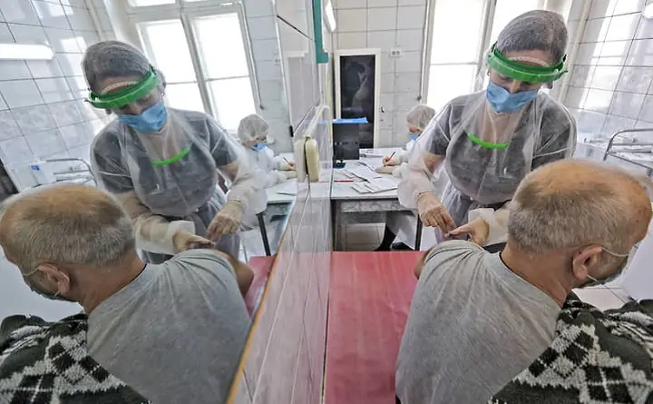Мужчине делают прививку. Фото Артема Краснова/Коммерсантъ