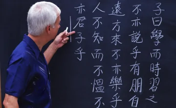 Учитель показывает китайские иероглифы. Фото donnews.ru