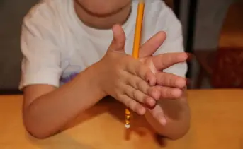 Мальчик держит в руках карандаш. Фото для иллюстрации klubmama.ru