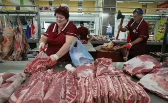 Женщина на рынке продаёт мясо. Фото novostink.ru.