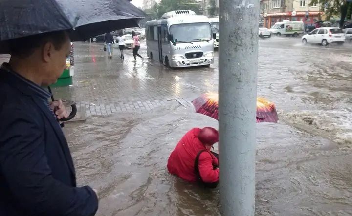 Ростовчанку сносит водой посреди улицы. Фото Юлии Казаровой.