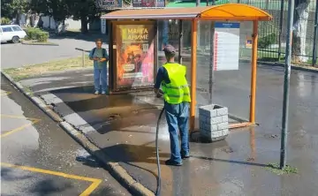 Работник коммунальной службы моет остановку. Фото rostov-gorod.ru