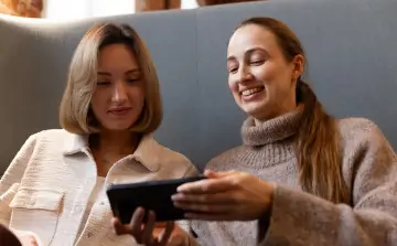 Девушки рассматривают фотографии с отпуска. Фото предоставлено пресс-службой МегаФона