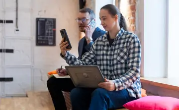 Пара со смартфонами и ноутбуком. Фото предоставлено ПАО «МегаФон»