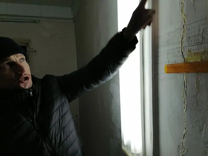 Владимир Кантура показывает трещину в стене своей квартиры. Фото donnews.ru